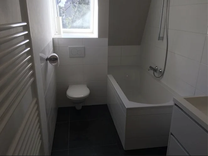 Lichte badkamer met toilet en bad